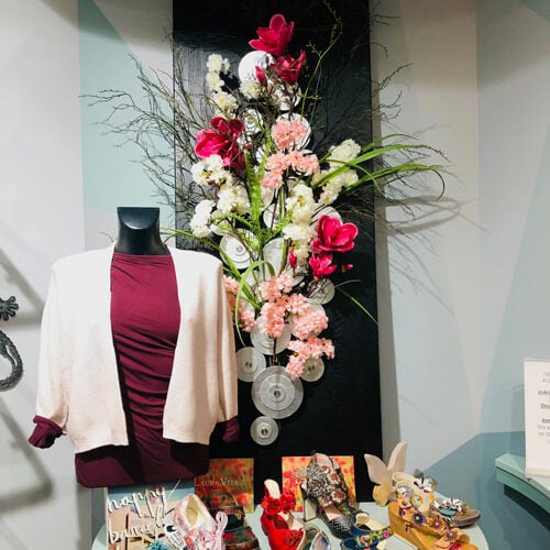 Barceloneta ausstellungstisch mit schuhen blumenbouquet frauen oberteil und jacke