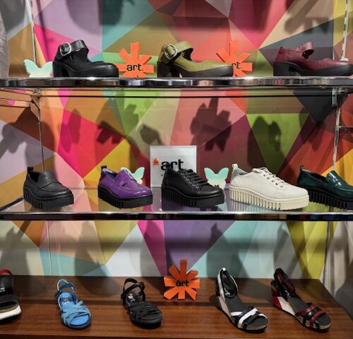 Verschiedene bunte Schuhe auf Regalen vor einem grafisch gestalteten Hintergrund.